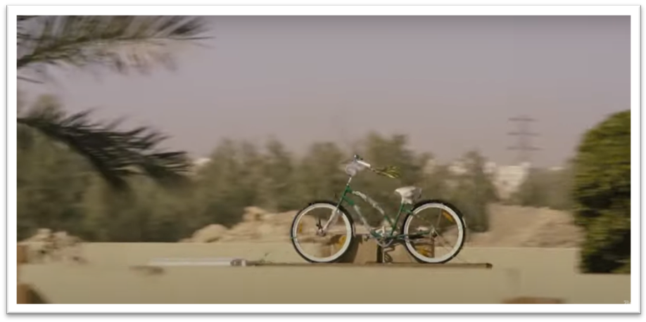 A green bicycle is seemingly floating through the air as it is driven along on the top of a truck. Description automatically generated with low confidence 