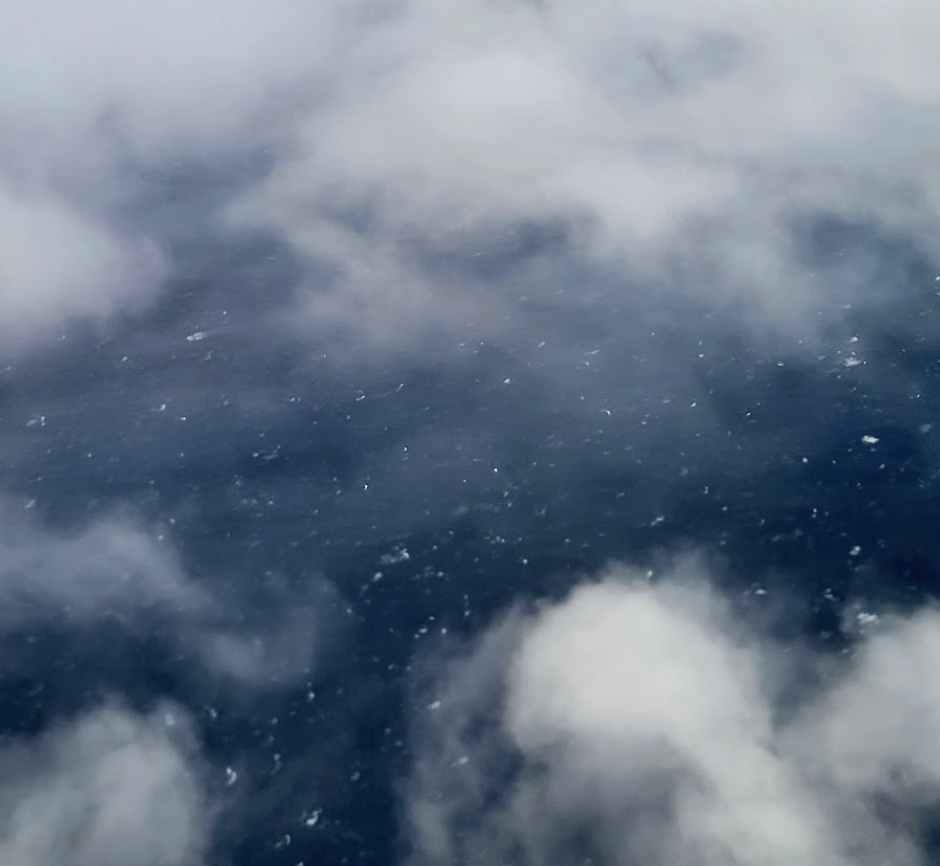 An image of clouds, with a dark sky visible between them.