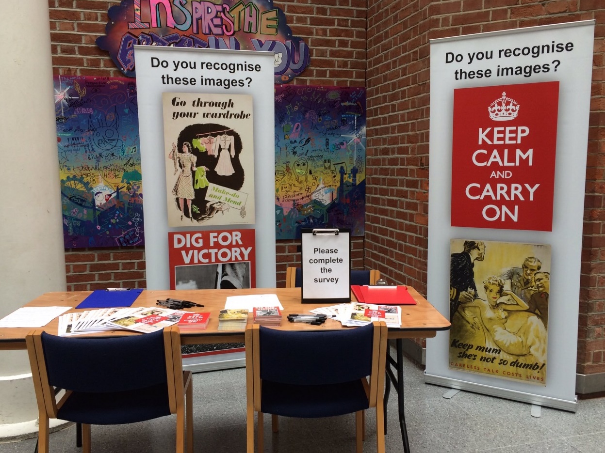 A table with chairs in front of posters AI-generated content may be incorrect.